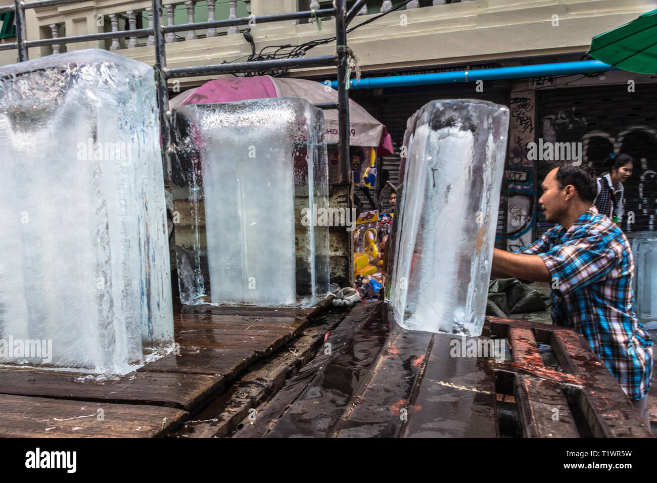 Mann picking Eiswürfel in der Khao San Road, Thailand Stockfoto