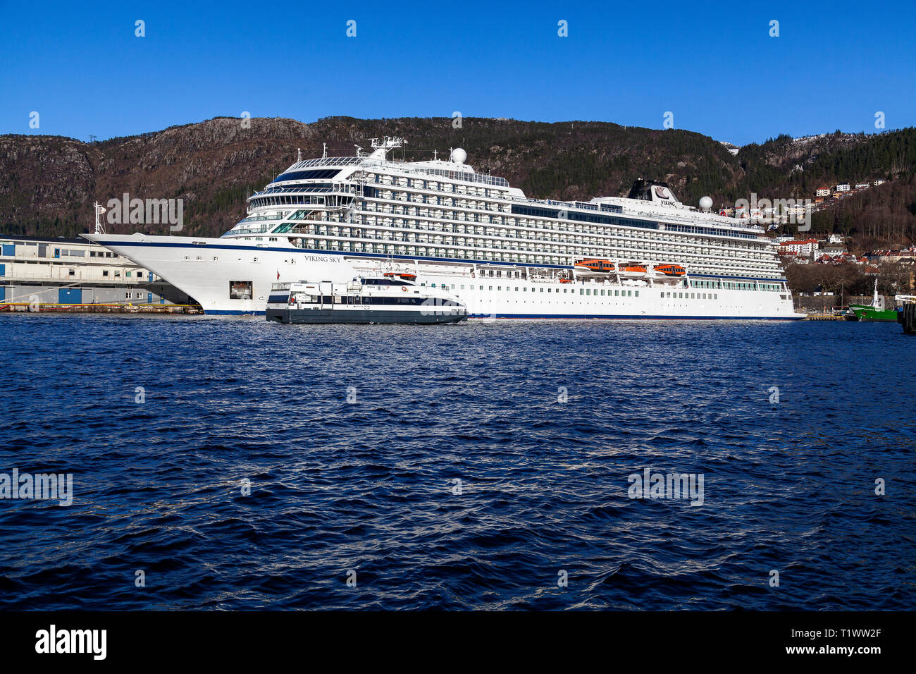 Lokale Fahrgast Katamaran Fjordkatt vorbei Kreuzfahrtschiff Viking Sky (skolten Terminal). Der Katamaran ist Ankunft in den Hafen von Bergen. Stockfoto