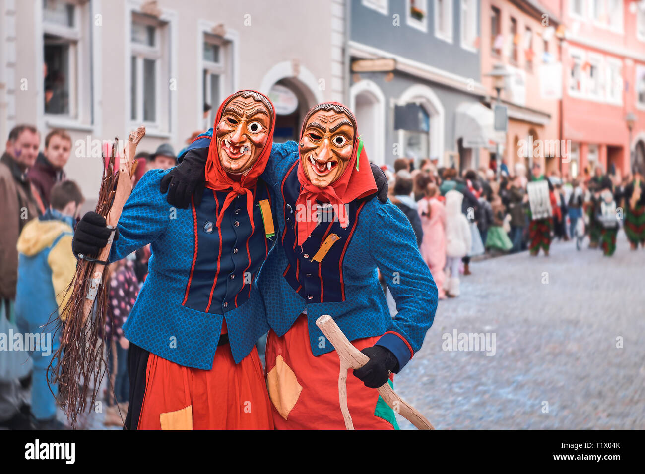 Zwei lustige Hexen sind einander umarmen. Straßenkarneval in Süddeutschland - Schwarz. Stockfoto