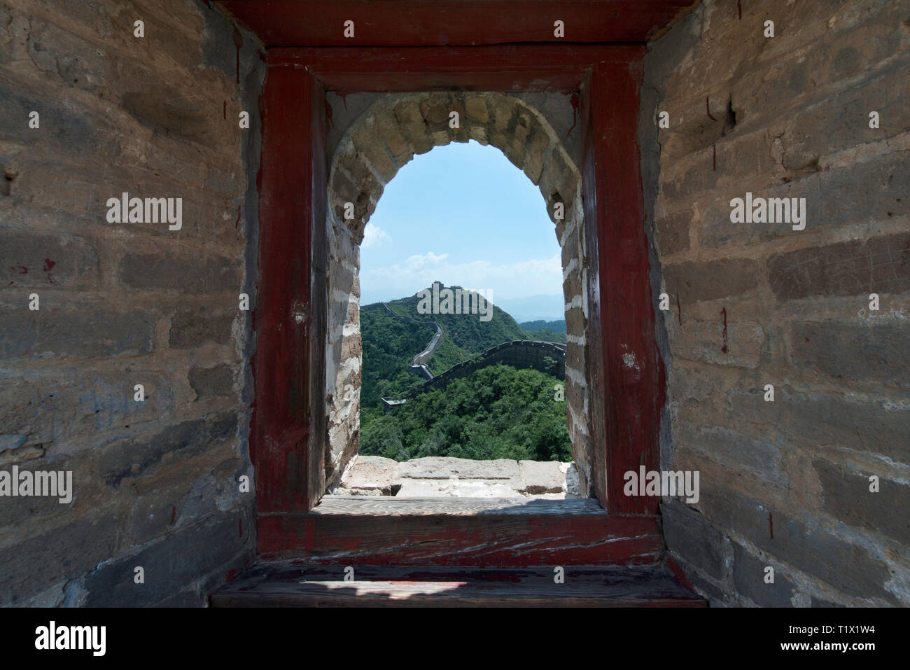 Blick durch ein Backstein Fenster einer Festung Wachturm von Mutianyu, einem Abschnitt der Großen Mauer von China im Sommer. Bezirk Huairou, Peking Stockfoto