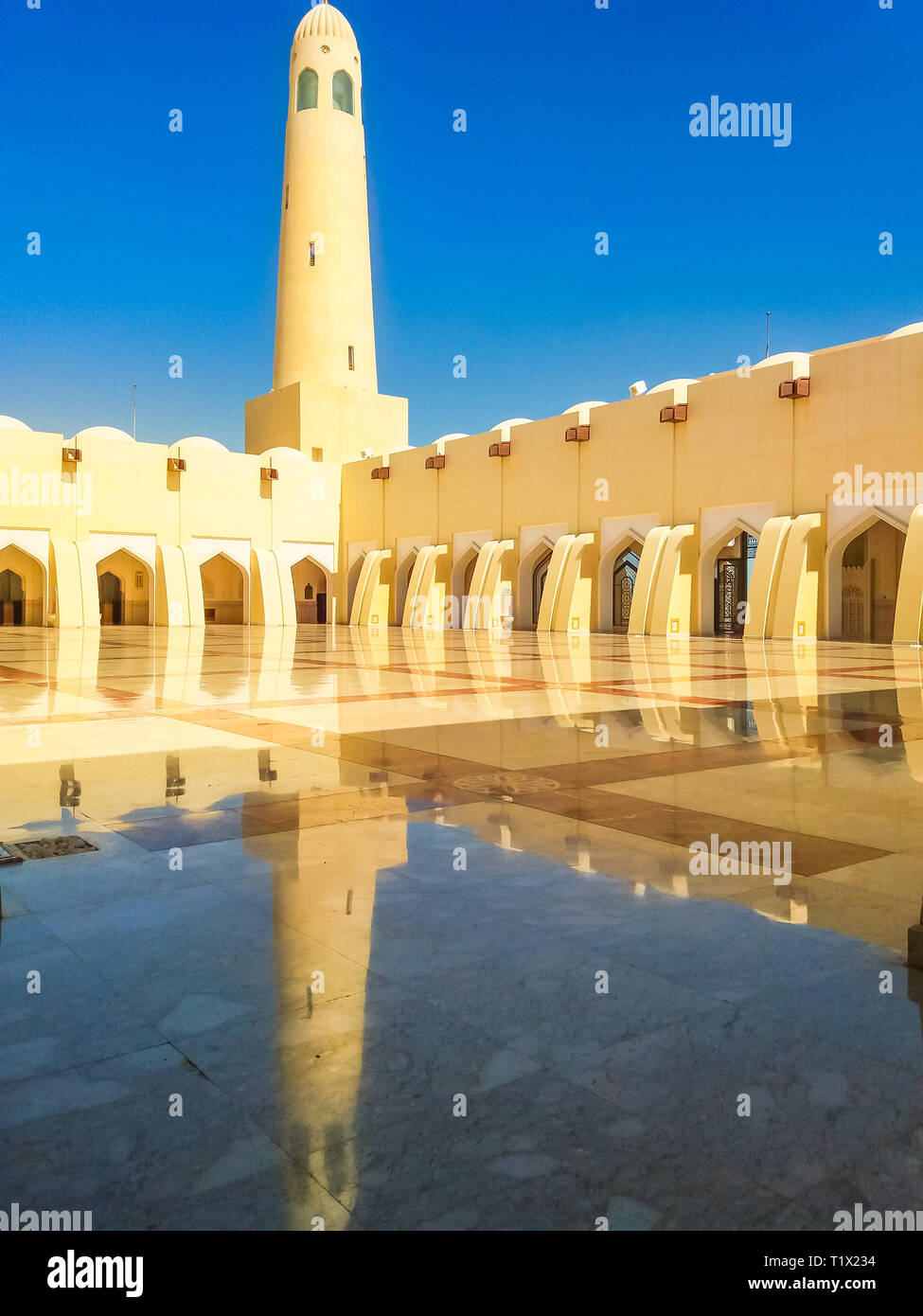 Doha, Katar - 21. Februar 2019: Innenhof mit Minaretten und Kuppeln an einem sonnigen Tag wider. Imam Abdul Wahhab Moschee oder Katar Staats Moschee in der Mitte Stockfoto