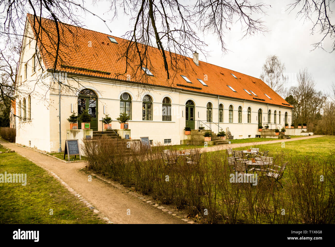 Das längliche Kavaliershaus Schloss Blücher verfügt über 12 Zimmer und Suiten, ein Restaurant sowie Sauna, Garten und Badesteg am See. Kavaliershaus in Fincken, Deutschland Stockfoto