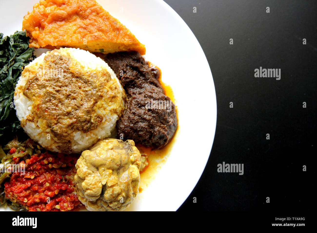 Nasi Padang Padang - Reis (mit Gehirn Kuh Curry, Beef Rendang und Omelett) Stockfoto