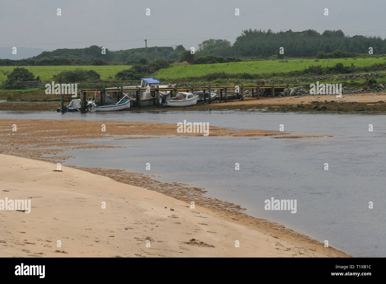 Inishowen Donegal, kleine Boote am Steg bei Ebbe auf dem culdaff Fluss, fließt in den Atlantik Culdaff Strand in County Donegal. Stockfoto