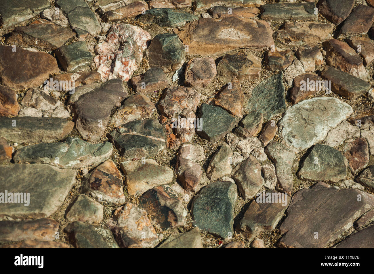 In der Nähe der Straße Bürgersteig aus groben Steinen, an einem sonnigen Tag in Caceres. Eine charmante Stadt mit einem vollständig erhaltenen Altstadt in Spanien. Stockfoto