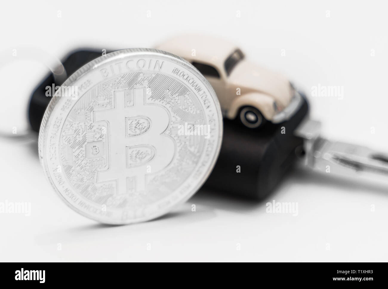 Silber physischen Bitcoin und Autoschlüssel auf weißem Hintergrund. Stockfoto