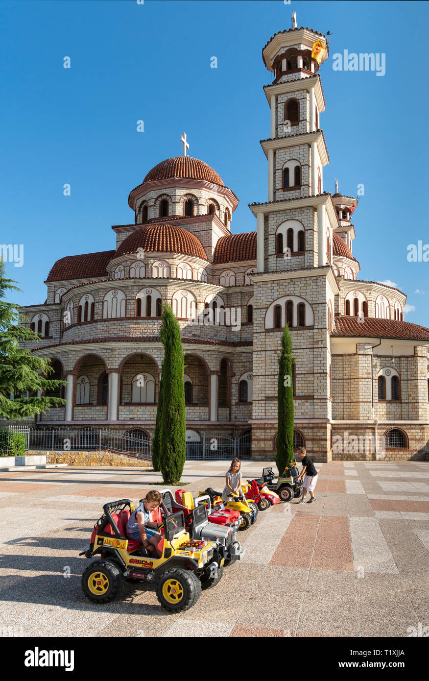 Kinder spielen auf miniatur Autos vor der Orthodoxen Kathedrale und Korca Korca, Südosteuropa Albanien. Stockfoto