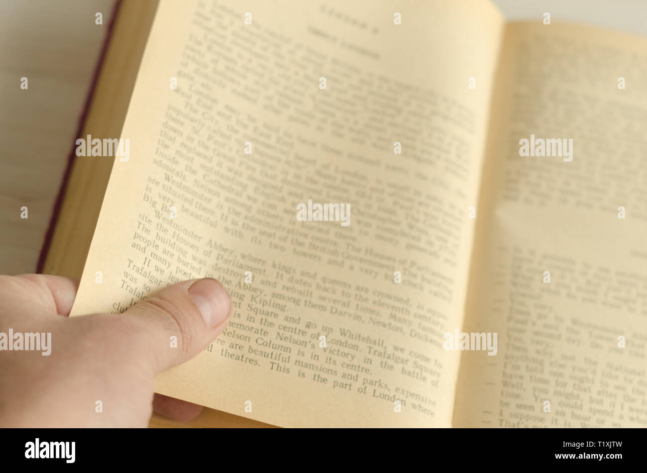 Ein Mann hält den Rand einer Buchseite. Welttag des Buches. Stockfoto