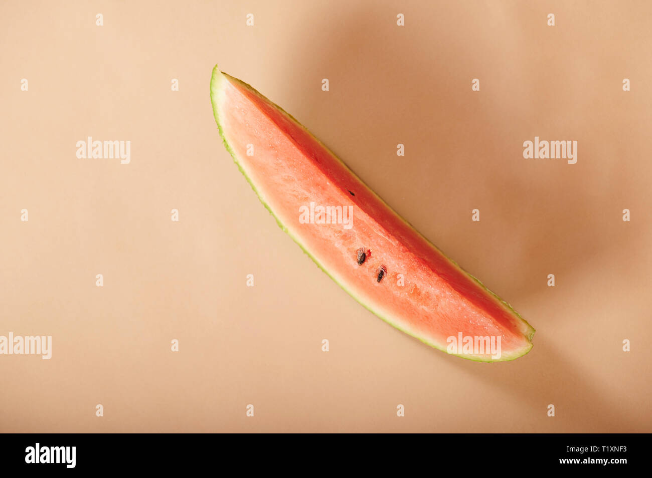 Eine Wassermelone Slice auf beige Farbe Hintergrund über anzeigen Stockfoto