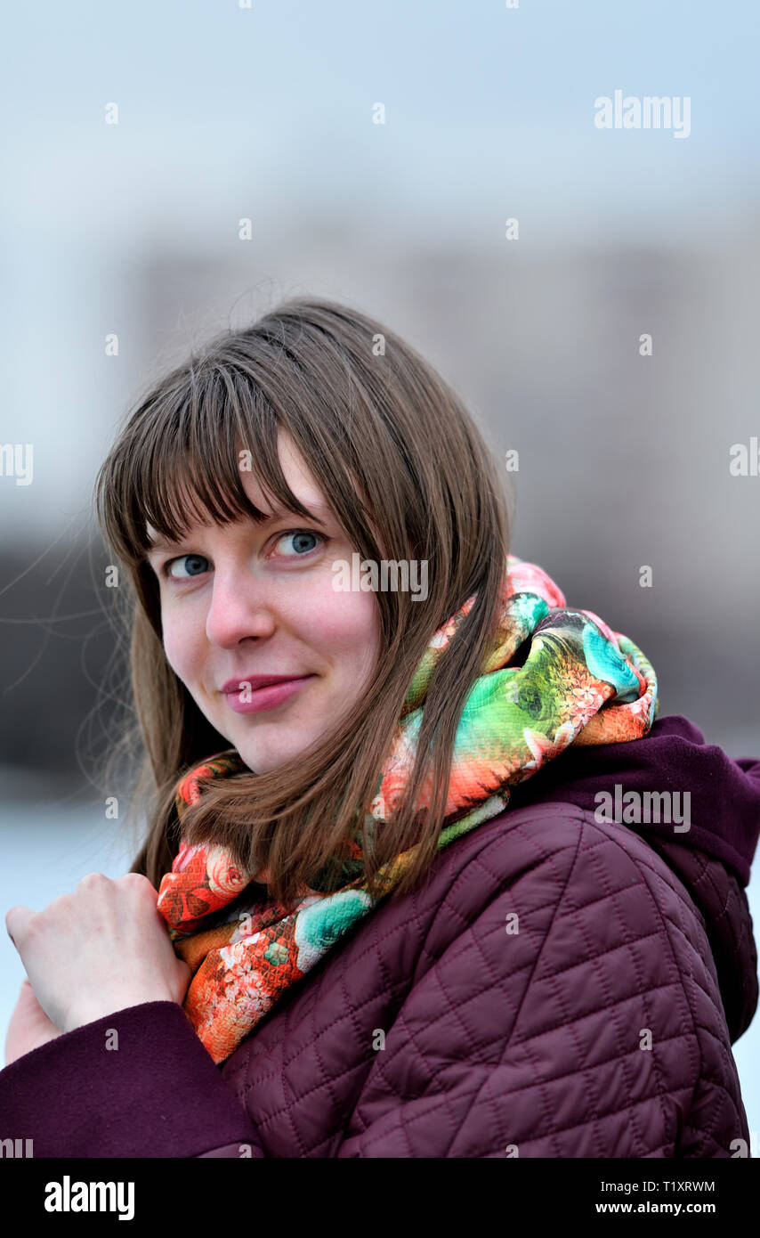 Eine junge Frau in einem lila Mantel. Stockfoto