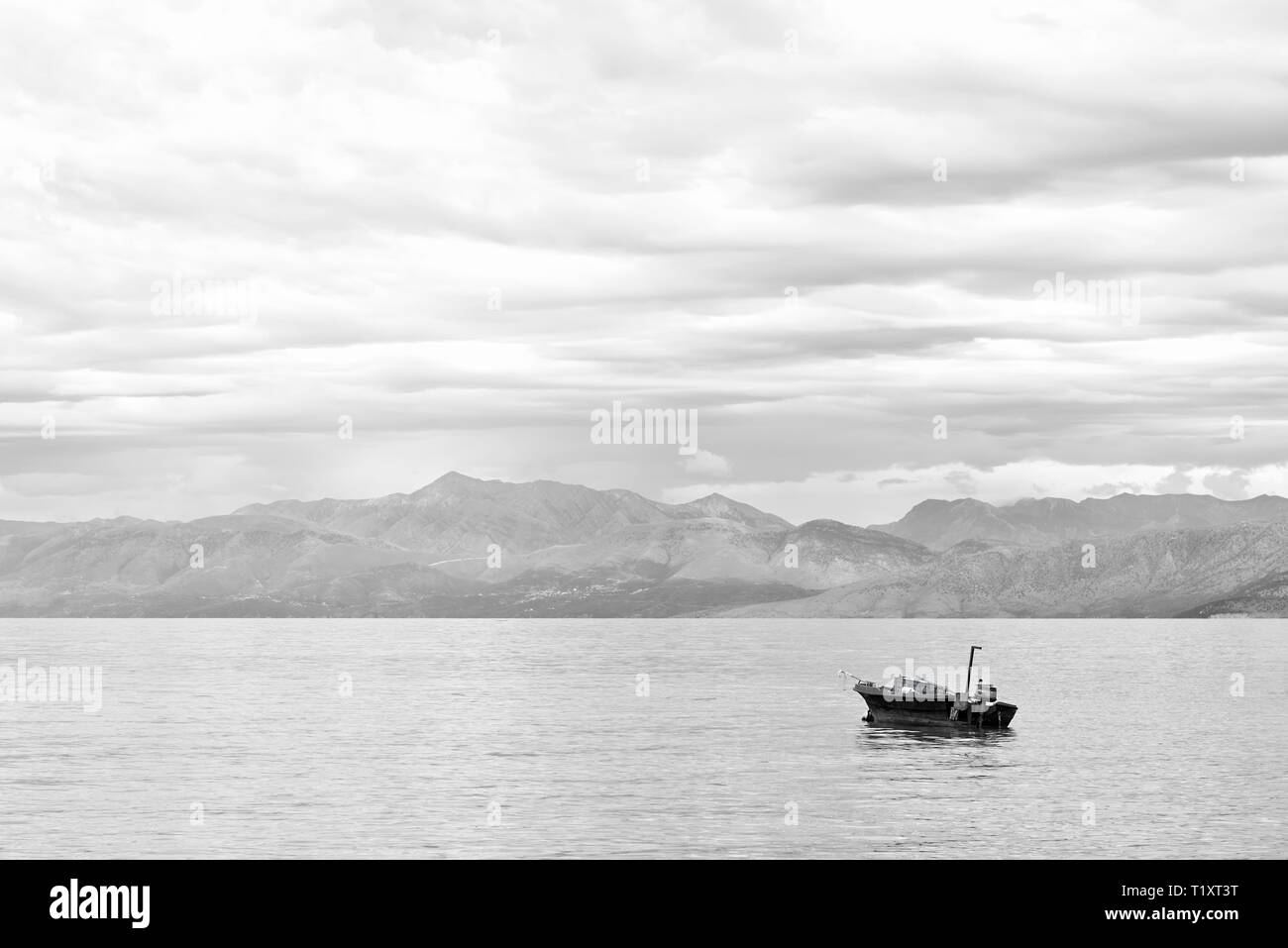 Fischerboot auf dem Meer mit Bergen im Hintergrund Stockfoto