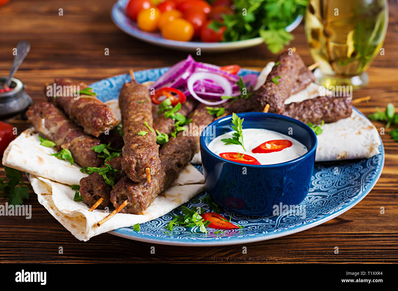 Türkisch und Arabisch traditionellen Ramadan mix Kebab Platte. Adana Kebab, Huhn, Lamm und Rind auf lavash Brot mit Soße. Ansicht von oben Stockfoto