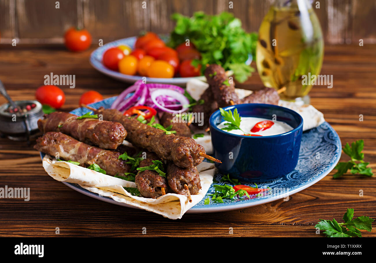 Türkisch und Arabisch traditionellen Ramadan mix Kebab Platte. Adana Kebab, Huhn, Lamm und Rind auf lavash Brot mit Soße. Ansicht von oben Stockfoto