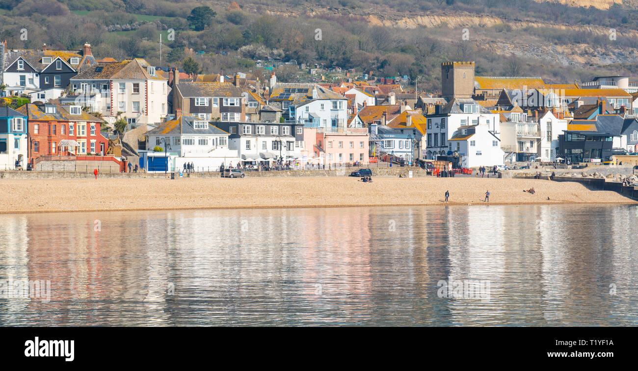 Lyme Regis, Dorset, Großbritannien. 29. März 2019. UK Wetter: Ein weiterer Tag der Sonne und strahlend blauen Himmel als Badeort von Lyme Regis in den frühen Frühling Hitzewelle weiter. Die malerischen Gebäude sind in den ruhigen Wasser wider. Credit: Celia McMahon/Alamy leben Nachrichten Stockfoto