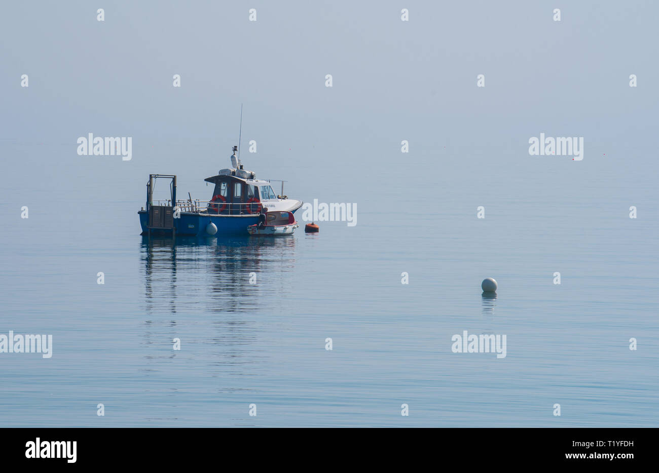 Lyme Regis, Dorset, Großbritannien. 29. März 2019. UK Wetter: Ein weiterer Tag der Sonne und strahlend blauen Himmel als Badeort von Lyme Regis in den frühen Frühling Hitzewelle weiter. Ein Fischerboot liegt im ruhigen Wasser wider. Credit: Celia McMahon/Alamy leben Nachrichten Stockfoto