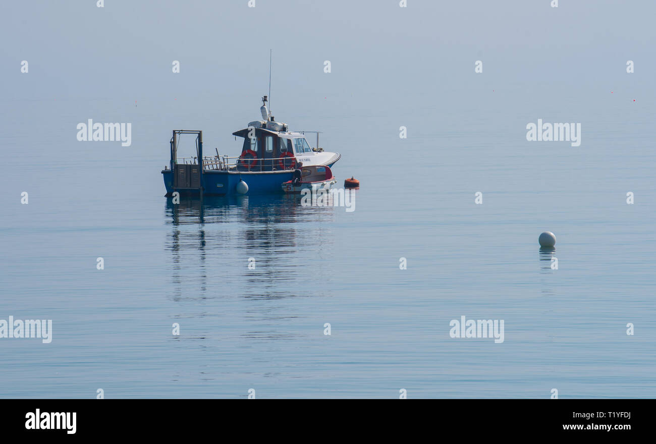 Lyme Regis, Dorset, Großbritannien. 29. März 2019. UK Wetter: Ein weiterer Tag der Sonne und strahlend blauen Himmel als Badeort von Lyme Regis in den frühen Frühling Hitzewelle weiter. Ein Fischerboot liegt im ruhigen Wasser wider. Credit: Celia McMahon/Alamy leben Nachrichten Stockfoto