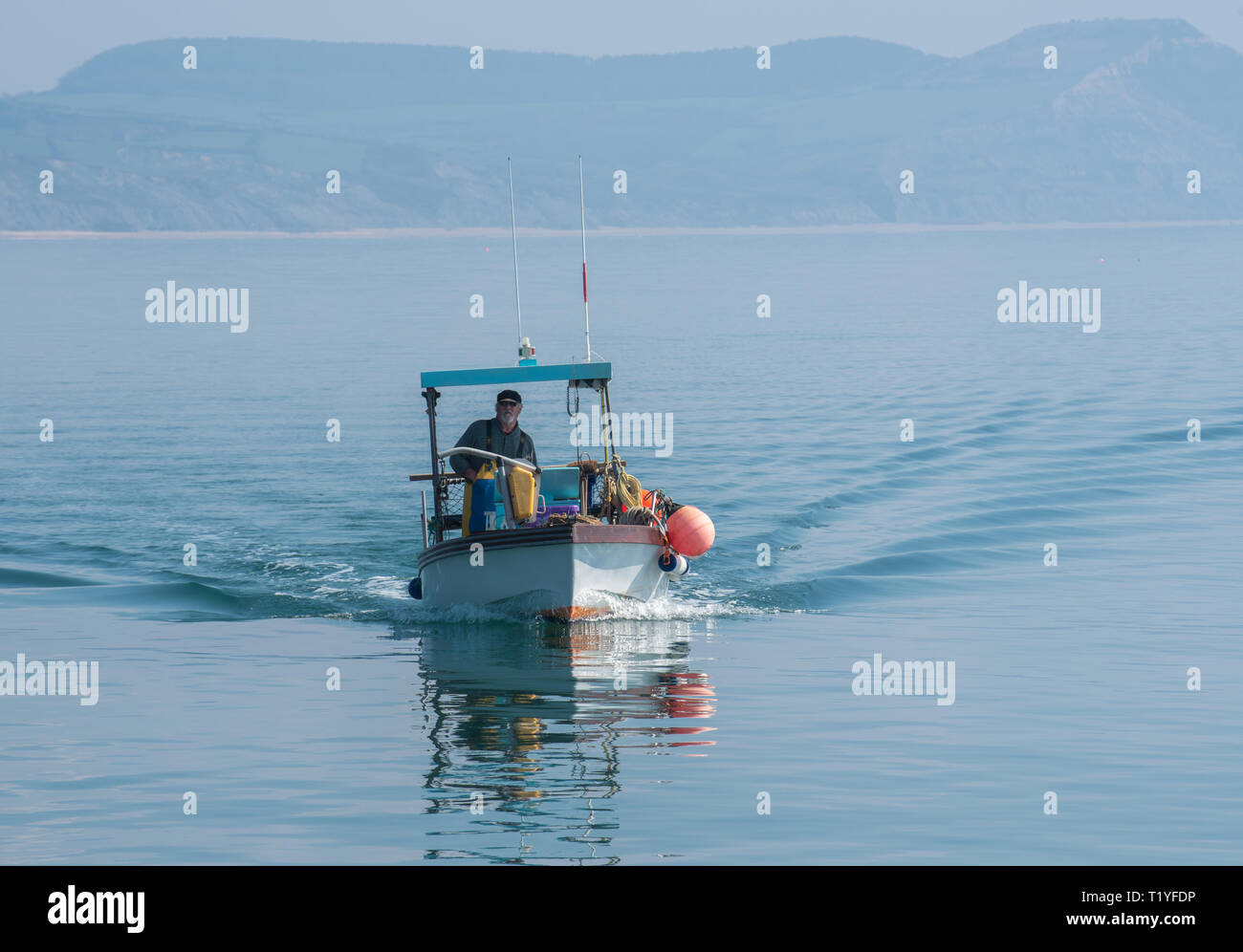 Lyme Regis, Dorset, Großbritannien. 29. März 2019. UK Wetter: Ein weiterer Tag der Sonne und strahlend blauen Himmel als Badeort von Lyme Regis in den frühen Frühling Hitzewelle weiter. Ein Fischerboot liegt im ruhigen Wasser wider. Credit: Celia McMahon/Alamy leben Nachrichten Stockfoto