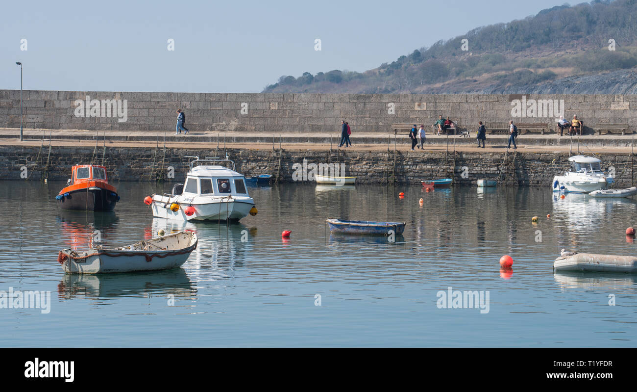 Lyme Regis, Dorset, Großbritannien. 29. März 2019. UK Wetter: Ein weiterer Tag der Sonne und strahlend blauen Himmel als Badeort von Lyme Regis in den frühen Frühling Hitzewelle weiter. Die Besucher gehen entlang der Cobb Hafen in der Sonne. Credit: Celia McMahon/Alamy leben Nachrichten Stockfoto