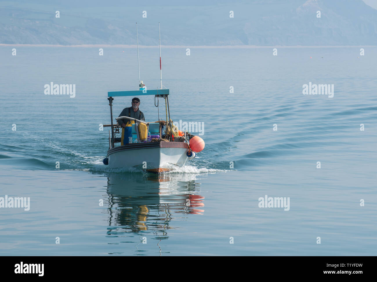 Lyme Regis, Dorset, Großbritannien. 29. März 2019. UK Wetter: Ein weiterer Tag der Sonne und strahlend blauen Himmel als Badeort von Lyme Regis in den frühen Frühling Hitzewelle weiter. Ein Fischerboot liegt im ruhigen Wasser wider. Credit: Celia McMahon/Alamy leben Nachrichten Stockfoto