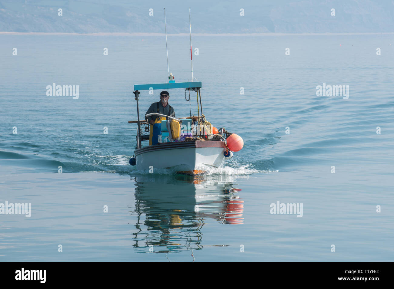Lyme Regis, Dorset, Großbritannien. 29. März 2019. UK Wetter: Ein weiterer Tag der Sonne und strahlend blauen Himmel als Badeort von Lyme Regis in den frühen Frühling Hitzewelle weiter. Ein Fischerboot liegt im ruhigen Wasser wider. Credit: Celia McMahon/Alamy leben Nachrichten Stockfoto