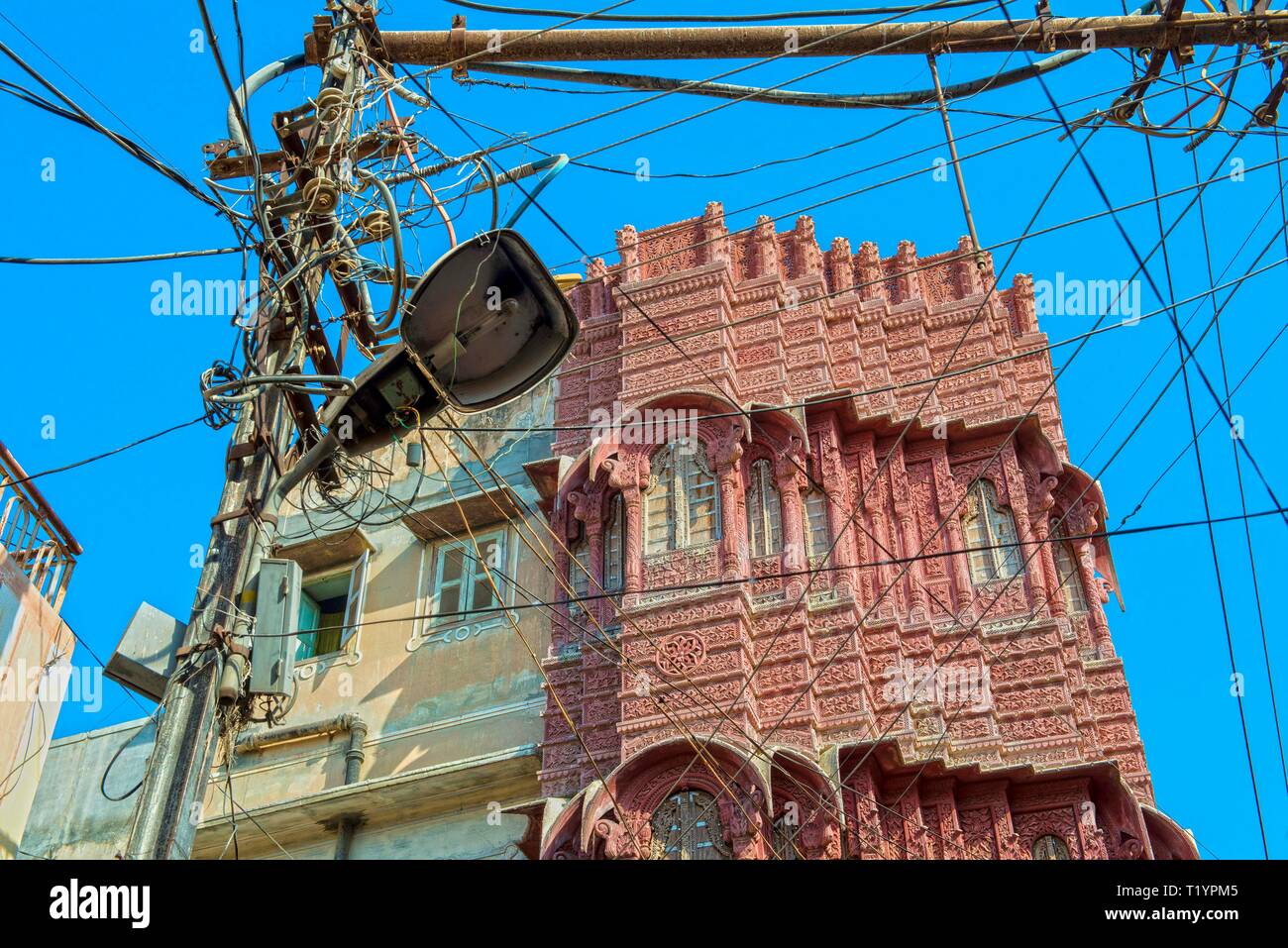 Indien, Rajasthan, BIKANER Gewirr von Stromleitungen im Kontrast zu einem gepflegten, historischen Gebäude in der Altstadt von Bikaner Stockfoto