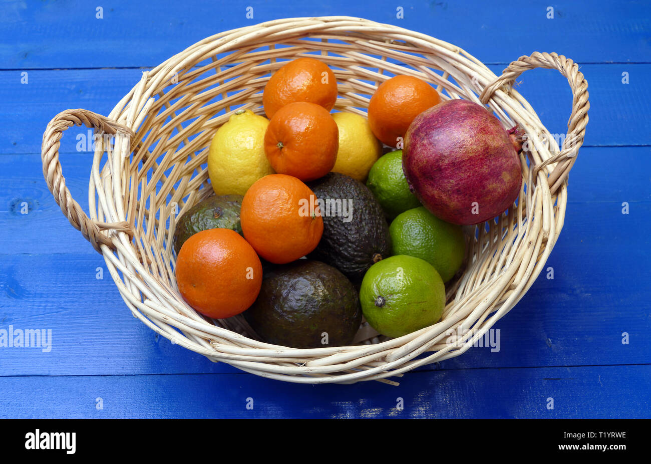 Exotische Früchte im Korb: Zitronen, Granadilla (Fruit of the Loom), Mandarinen, Avocados. Stockfoto