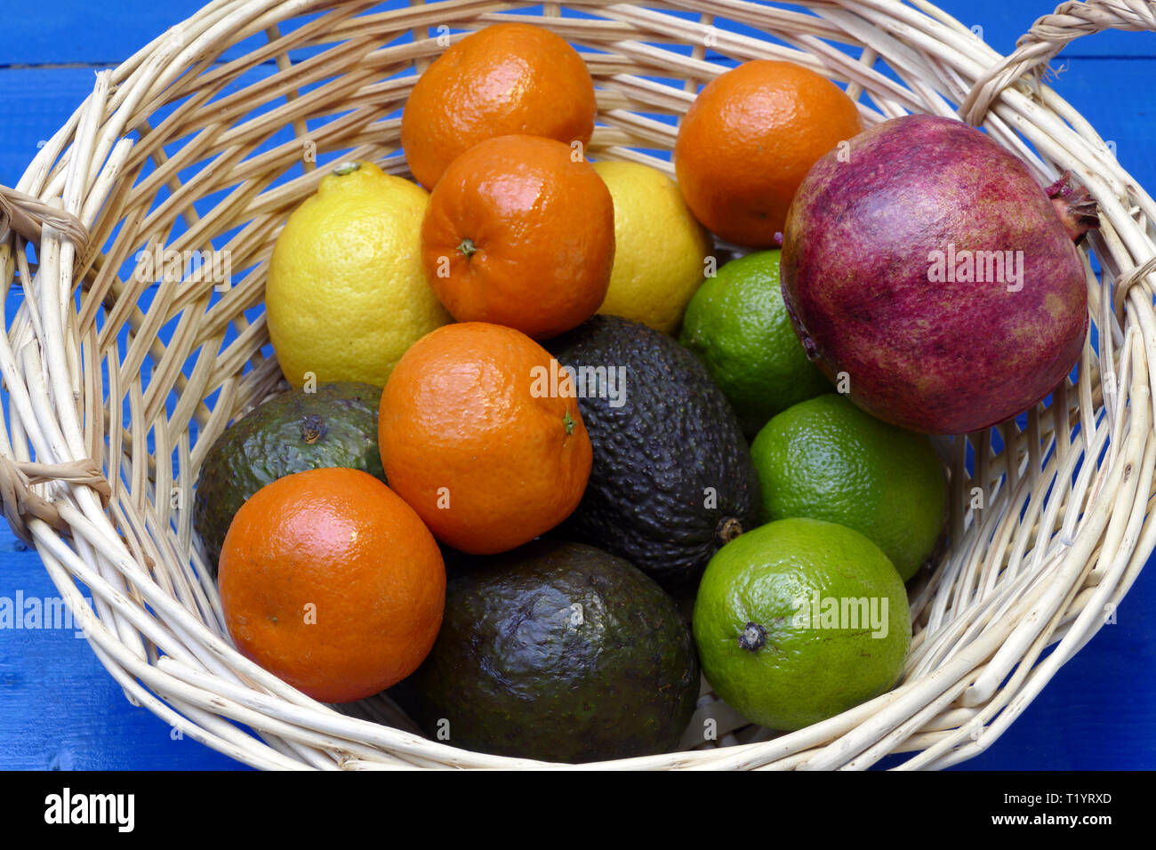 Exotische Früchte im Korb: Zitronen, Granadilla (Fruit of the Loom), Mandarinen, Avocados. Stockfoto