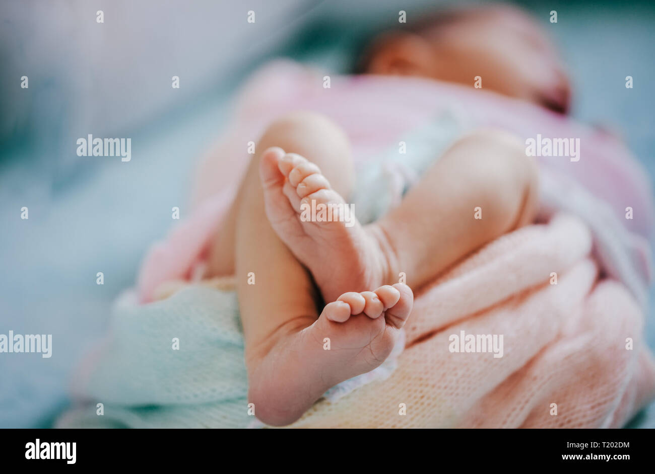 Neugeborenes Baby Füße hautnah. Weiche Pastelle Hintergrund, Aquamarin, rosa, pfirsich wickeln. Stockfoto