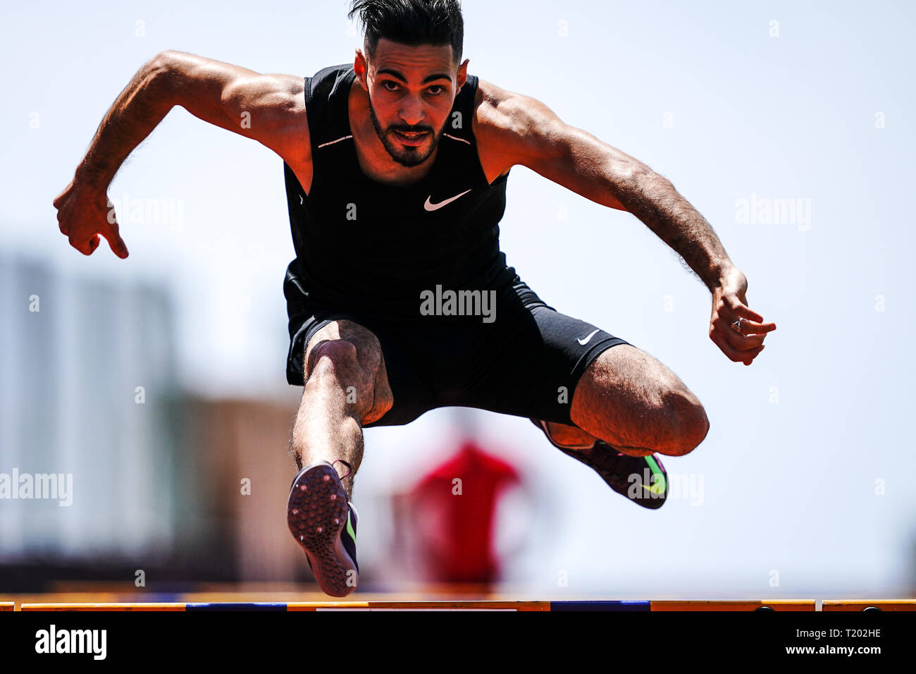 Tenerife, Spain - March 21, 2019: An athlete jumps over a hurdle during practicing on a running track Stockfoto