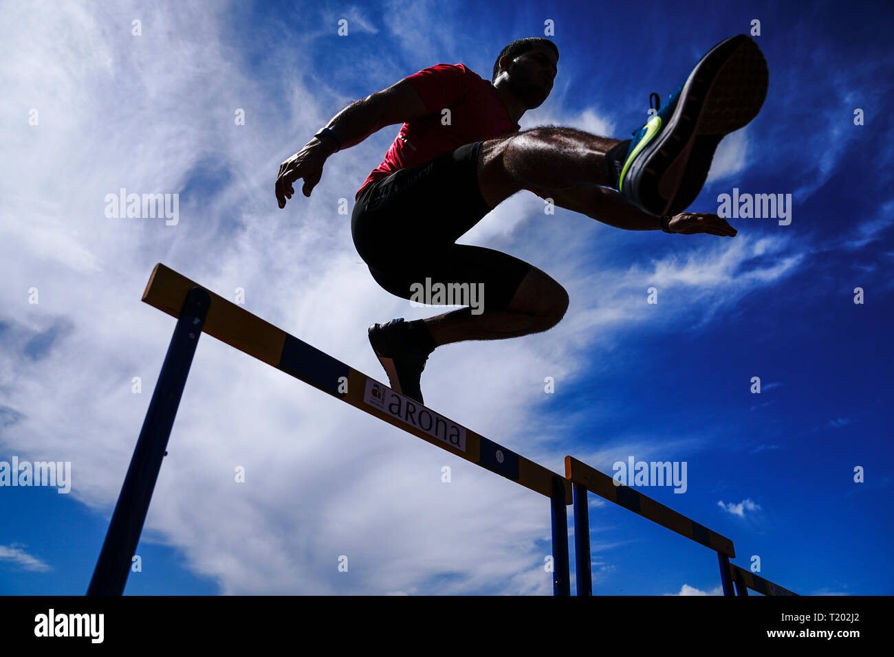 Teneriffa, Spanien - 21. März 2019: Ein Sportler springt über eine Hürde beim Üben auf eine Laufstrecke Stockfoto