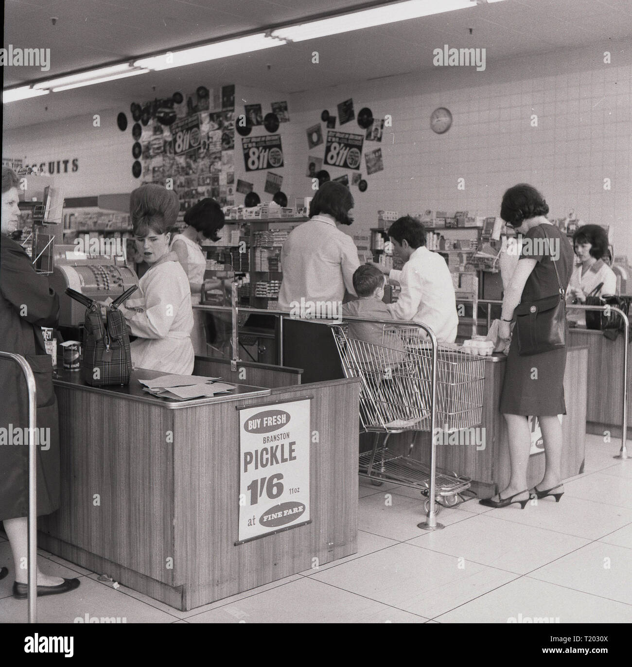 1960, historische, weibliche Käufer an der Kasse Kassen an einem neuen 'Feine Kost' Supermarkt, England, UK. Obwohl Supermärkte waren langsam in das Vereinigte Königreich, das Ende der Rationierung sah den persönlichen Konsum erhöhen zu nehmen und wenn es nur 50 oder so in den frühen 50er Jahren wurden, bis zum Ende des Jahrzehnts über 500 geöffnet hatte, einschließlich Fiine Fahrpreis, Premier und Victor Wert. Stockfoto
