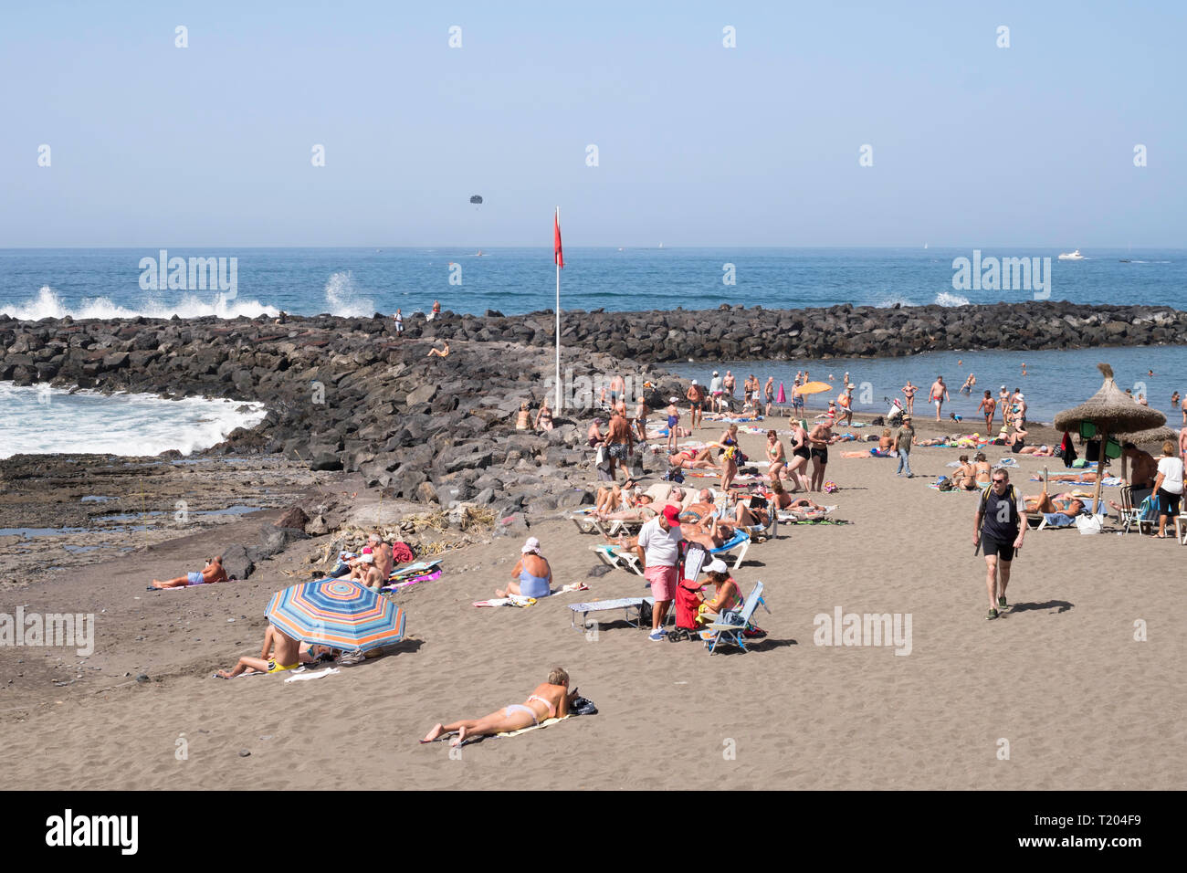 Menschen Sonnenbaden am Strand an der Costa Adeje, Teneriffa, Kanarische Inseln. Stockfoto