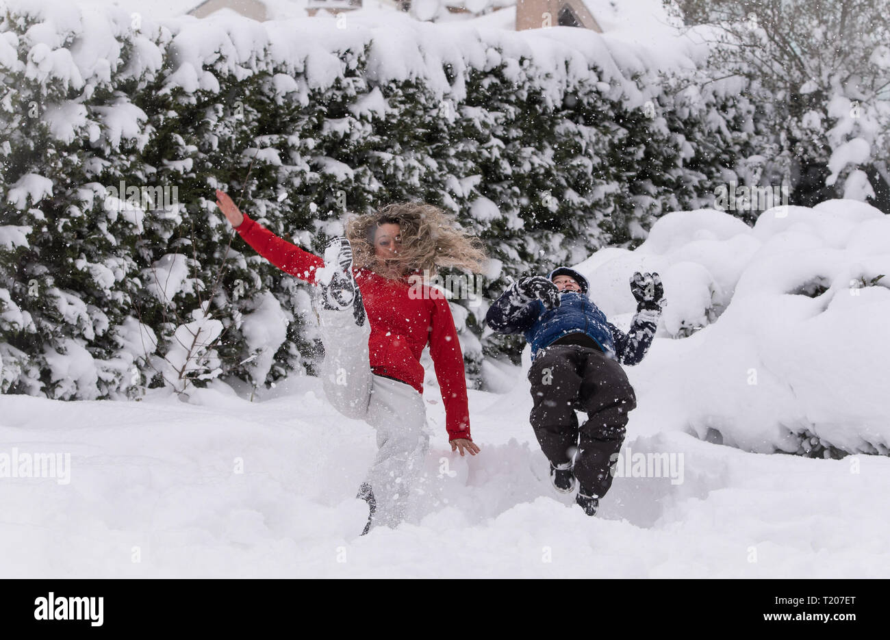 Mutter und Kind springen in tiefem Schnee, Spaß Stockfoto