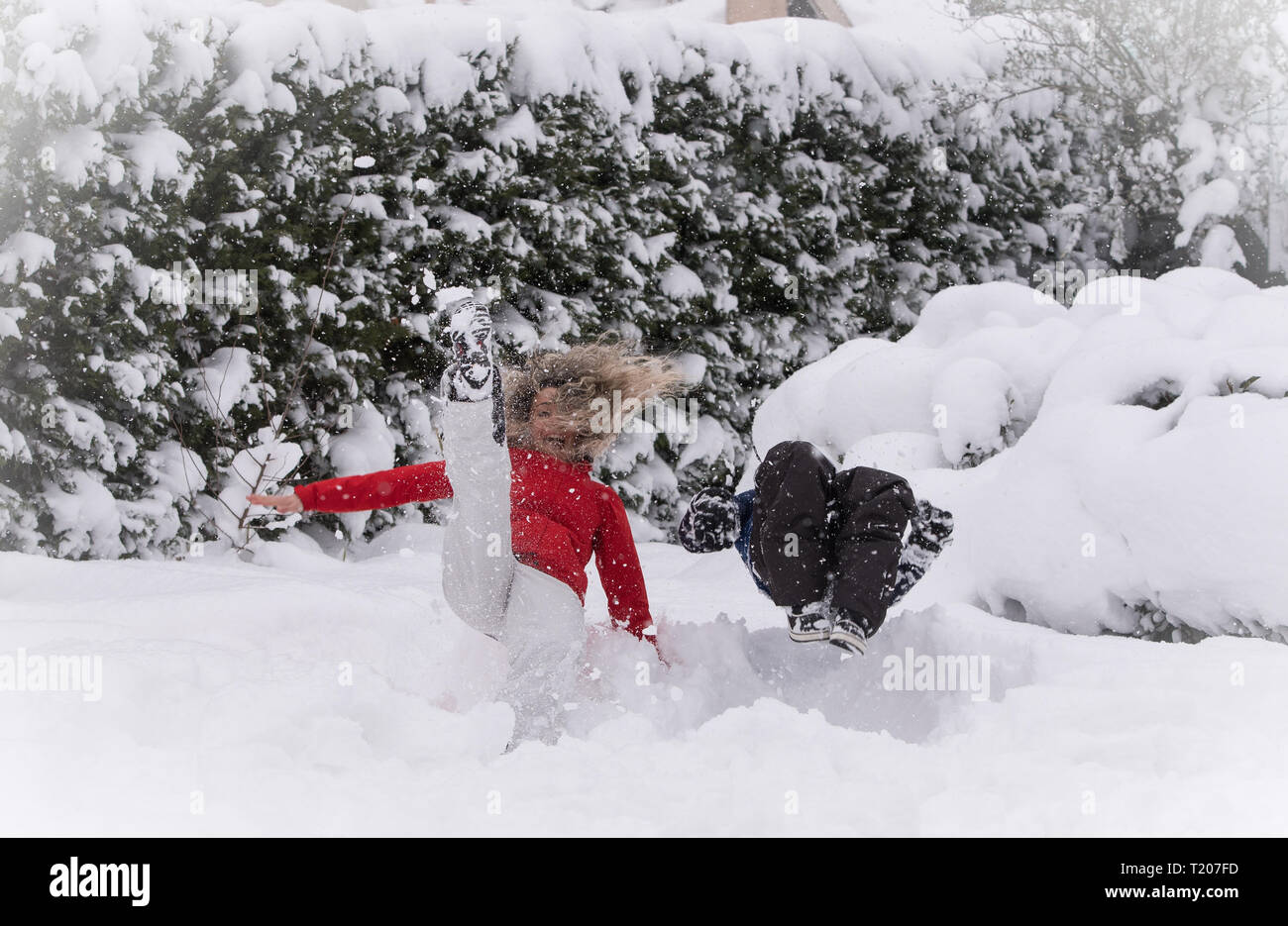 Mutter und Kind springen in tiefem Schnee, Spaß Stockfoto