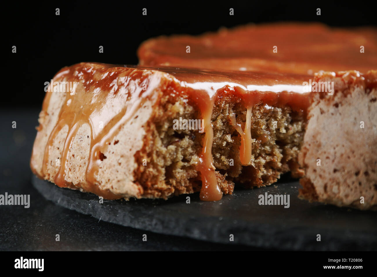 Pie mit Karamell schließen bis auf dunklem Hintergrund. Kuchen mit Banane und Karamell. Stockfoto