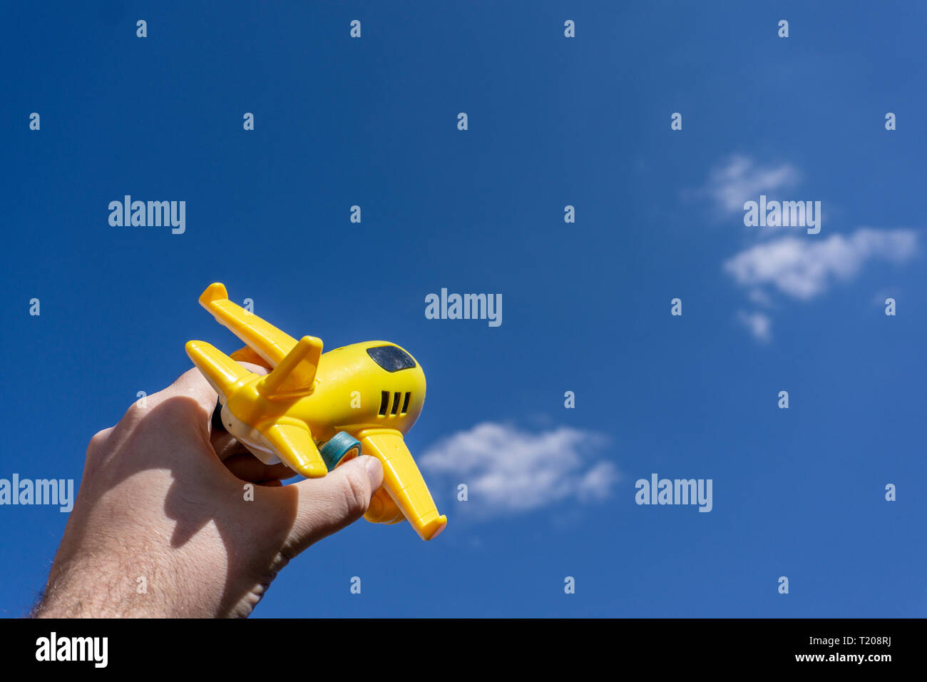 Gelb Spielzeug Flugzeug in der schönen blauen Himmel, negativen Raum, Konzept der gehen auf einen zauberhaften Urlaub, traumziel Fliegen Stockfoto