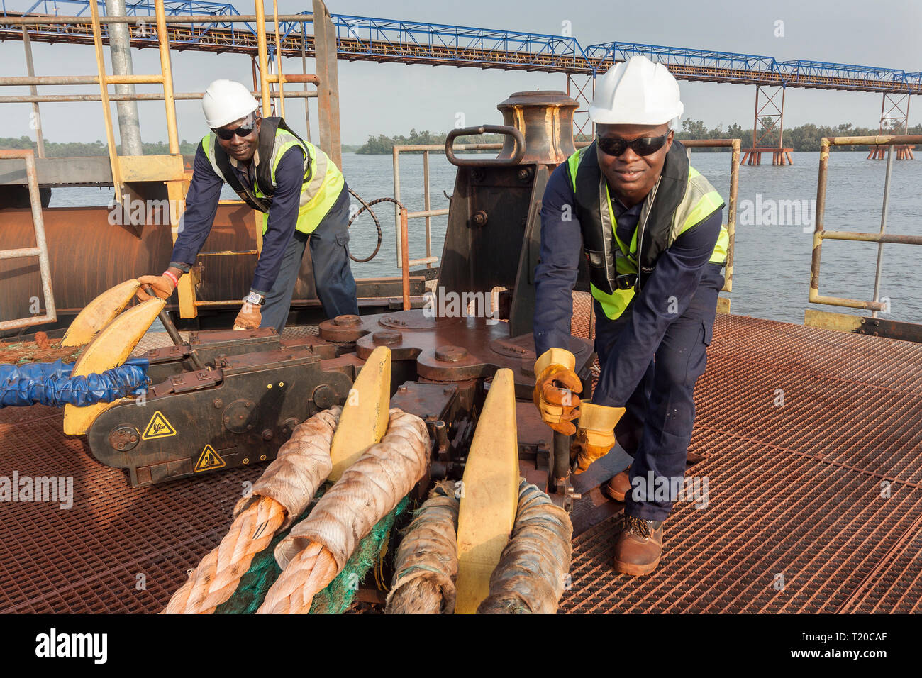 Port Operations für den Transport von Eisenerz. Dolphin Anlegestelle Anlegestelle mit rigger mit Quick release Seil Haken als Schiff setzt Segel Stockfoto
