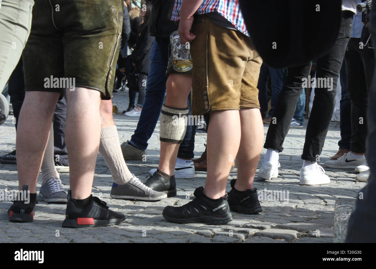 Jungs in bayrischen Lederhosen auf dem Oktoberfest. Gemischt mit lässigen Sportschuhen und Halbstrumpf mit Haferlschuh. Stockfoto