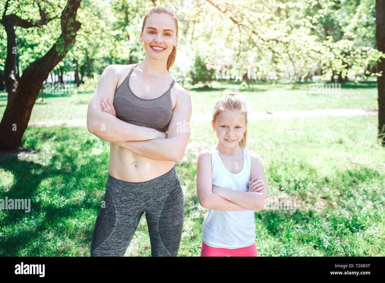 Zwei zuversichtlich Mädchen stehen und posieren. Sie sind auf der Suche direkt zur Kamera. Mädchen sind dabei die Hände gekreuzt. Yoga und Pilates Konzept. Stockfoto