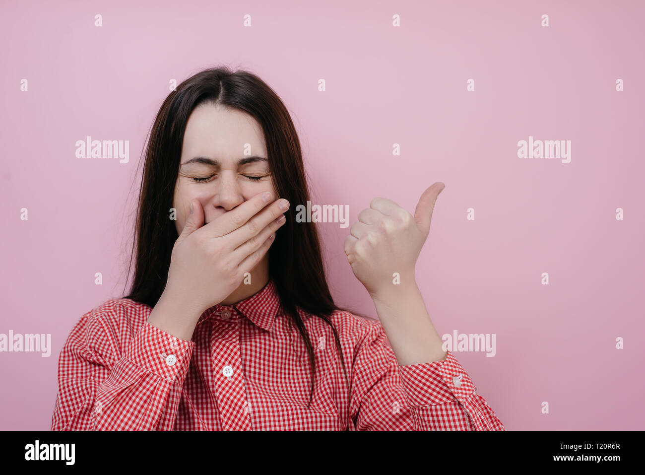 Portrait von gut aussehenden jungen Mädchen kichert voll Freude, eine Hand Mund deckt als versucht zu Lachen, zeigt sich an der Leere Kopie Raum Stockfoto