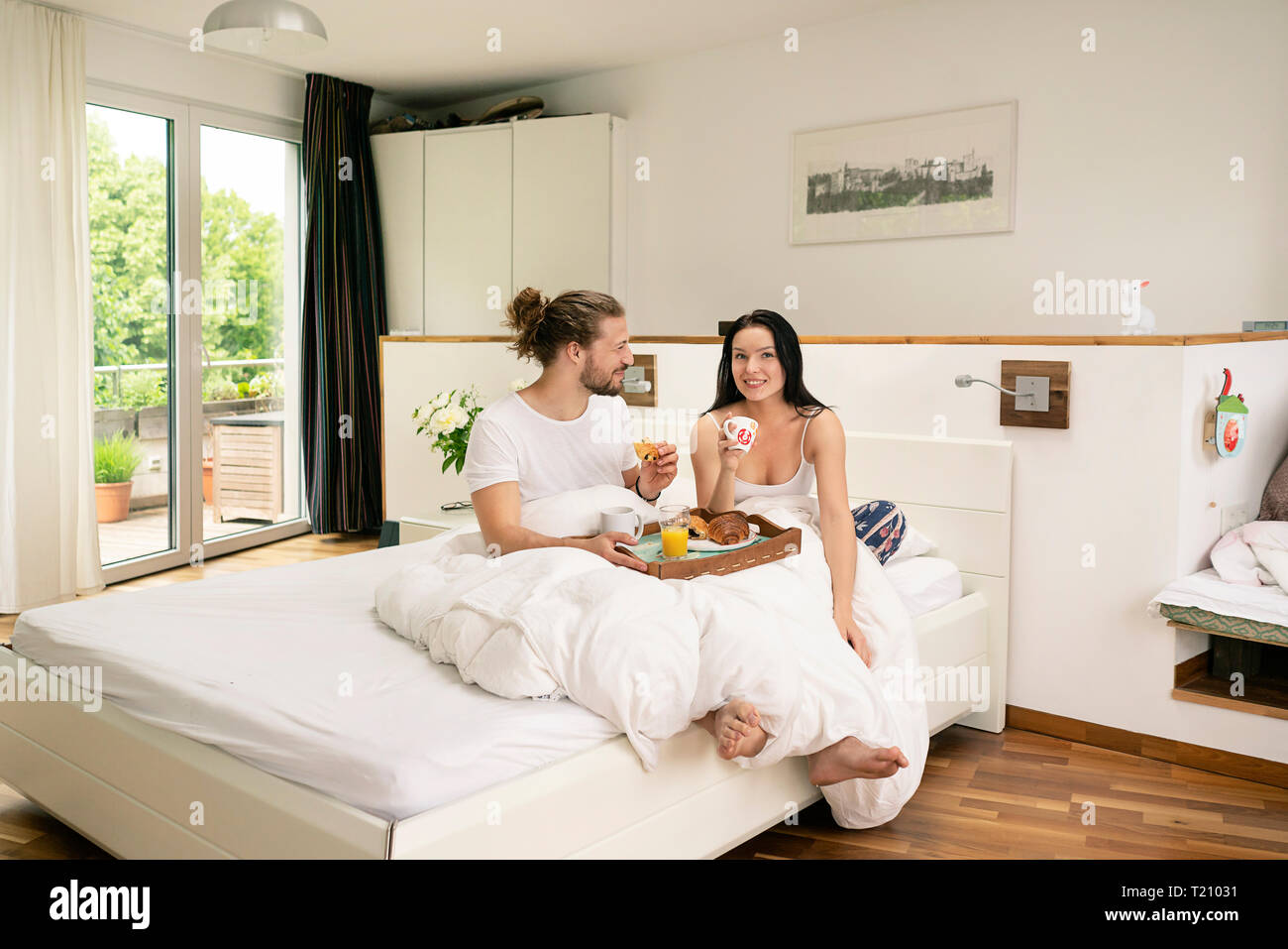 Liebevolle paar mit Frühstück im Bett Stockfoto