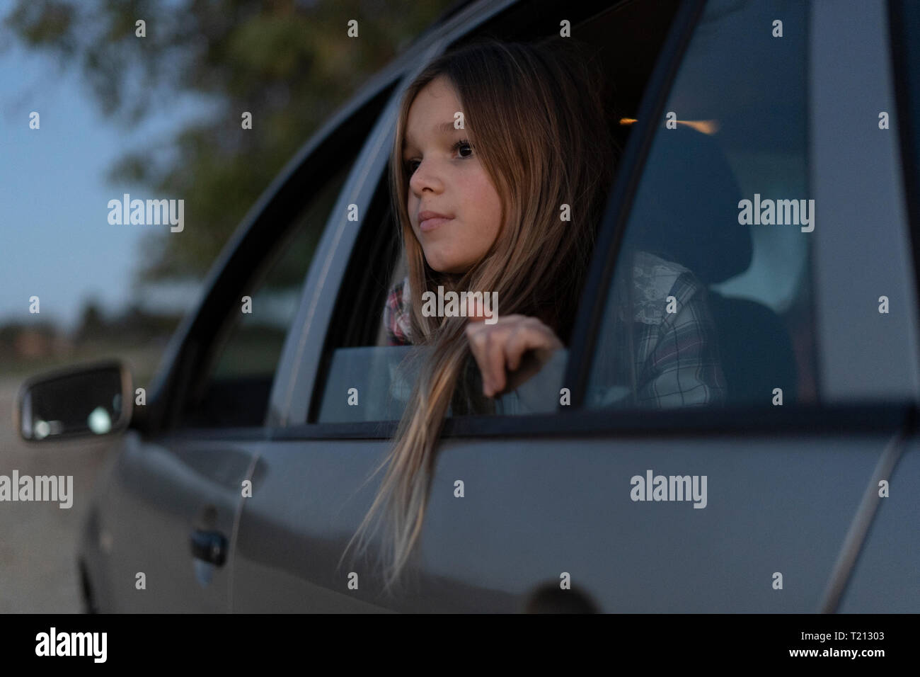 Mädchen aus dem Auto Fenster am Abend Stockfoto