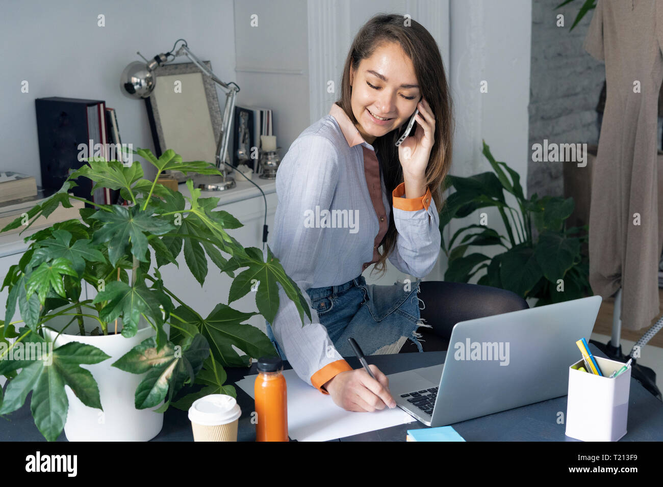 Junge Geschäftsfrau, die von zu Hause aus arbeiten, Telefonieren Stockfoto