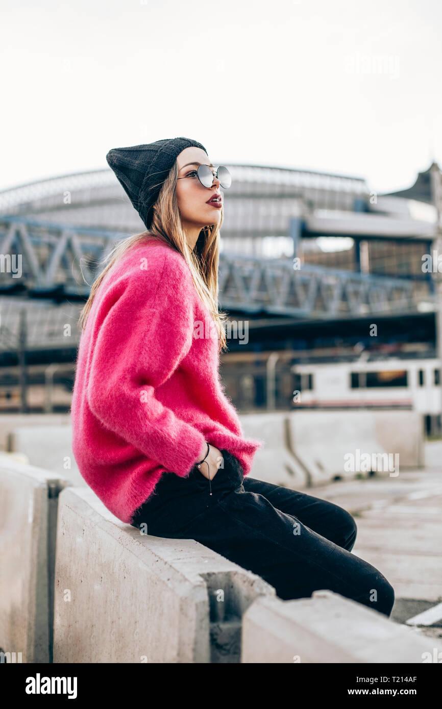 Portrait von modische junge Frau mit Sonnenbrille, Mütze und rosa Strickpullover Stockfoto