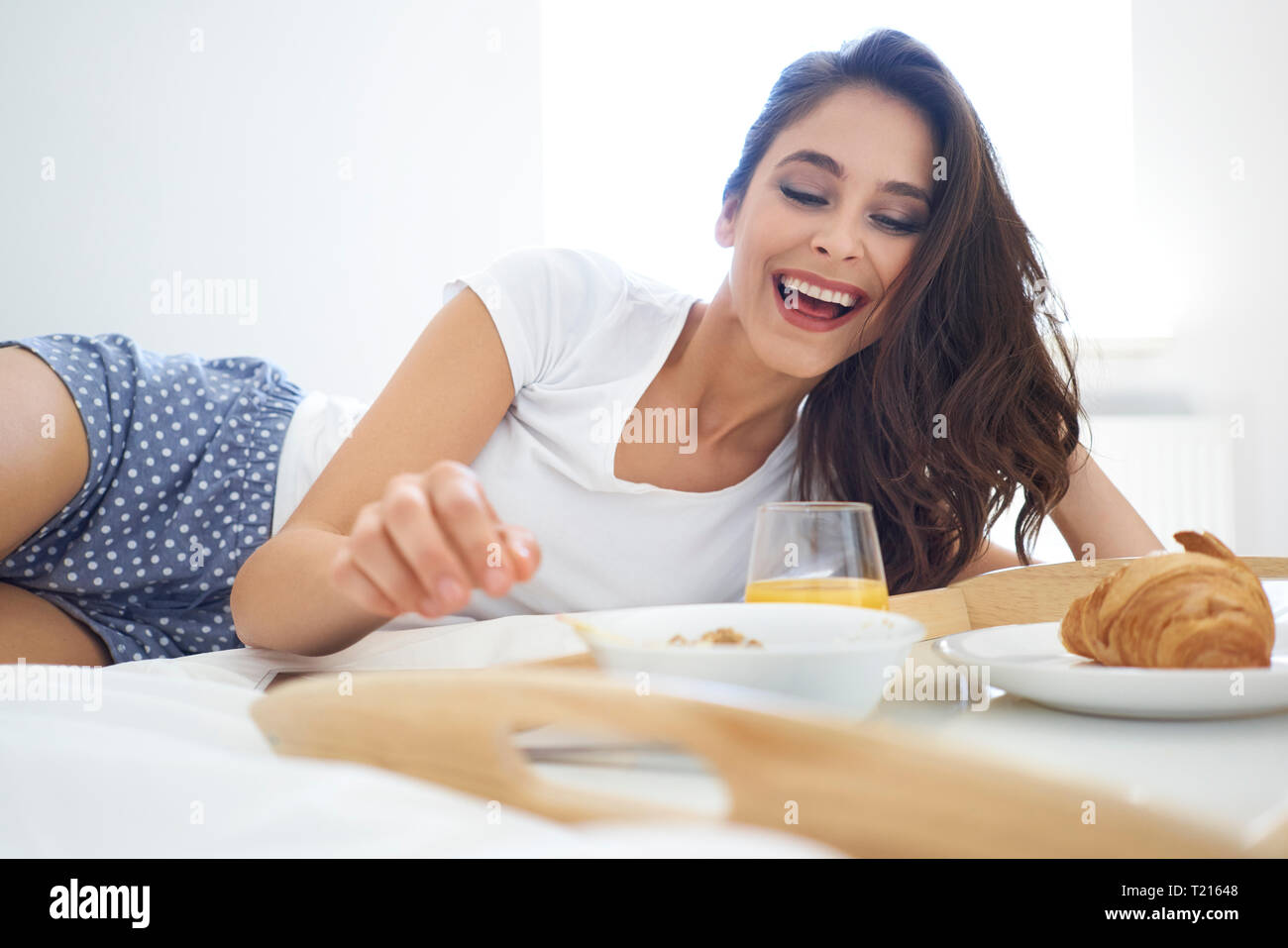 Junge Frau, die genießen das Frühstück im Bett Stockfoto