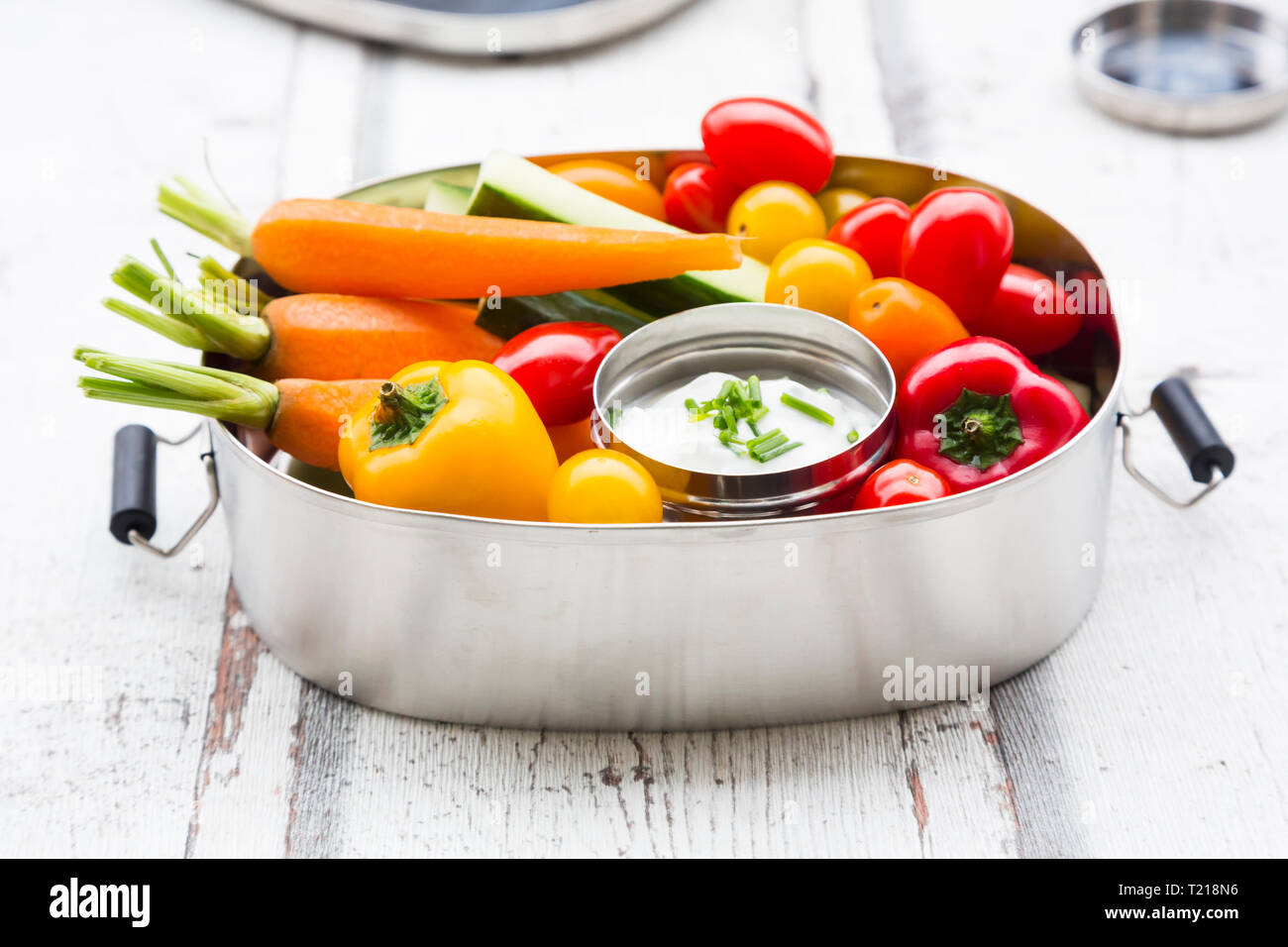 Lunch Box mit Karotte, Paprika, Gurke, Tomaten und Schnittlauch dip Stockfoto