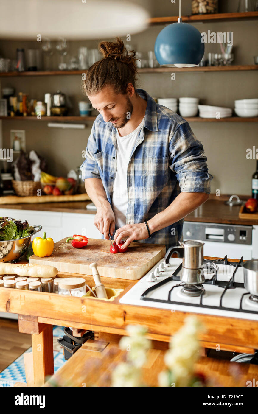 Junger Mann essen zu Hause vorbereiten, schneiden Gemüse Stockfoto