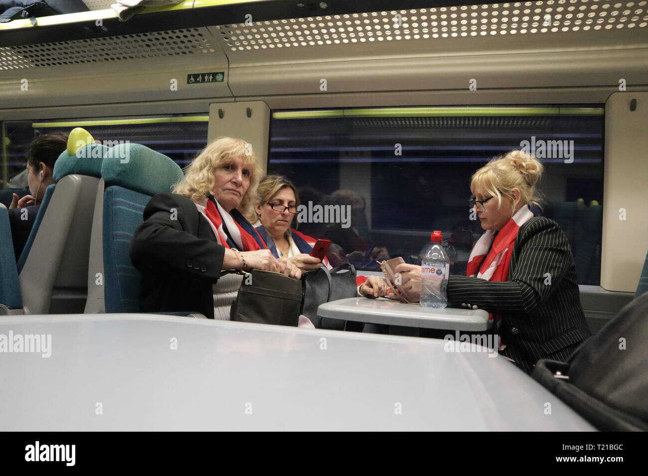 3 Frauen mit Union Jack Fahnen in einem Zug nach Abstimmung über Brexit am 29. März 2019 Stockfoto