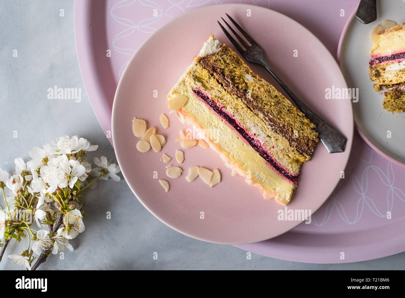 Scheiben von Mousse au chocolat Torte auf einem Teller und einer Tulpe Blumen in einer weißen Vase Stockfoto