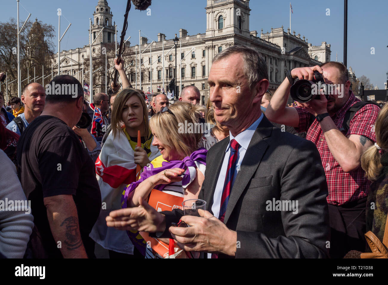 London, Großbritannien. 29. März 2019. Eine brexit unterstützt MP Gespräche mit den Demonstranten auf dem Weg ins Parlament als Protest gegen die Untätigkeit der britischen die EU zu verlassen heute die ursprüngliche Frist von Artikel 50. Sie hielten Plakate und Fahnen und skandierten Parolen und blockierten die Straße vor dem Parlament zur Mittagszeit. Später wurden sie von einem Verlassen verband bedeutet März mit zwei Orange Marching Bands verlassen. Sie gedrängt um den Eingang zum Parlament, Fragen zu den wenigen Abgeordneten, die sich durch die Menge ging. Nur wenige bleiben Unterstützer kamen, darunter # EUsupergirl Madeleina Kay als Brittania und die Atmosphe Stockfoto